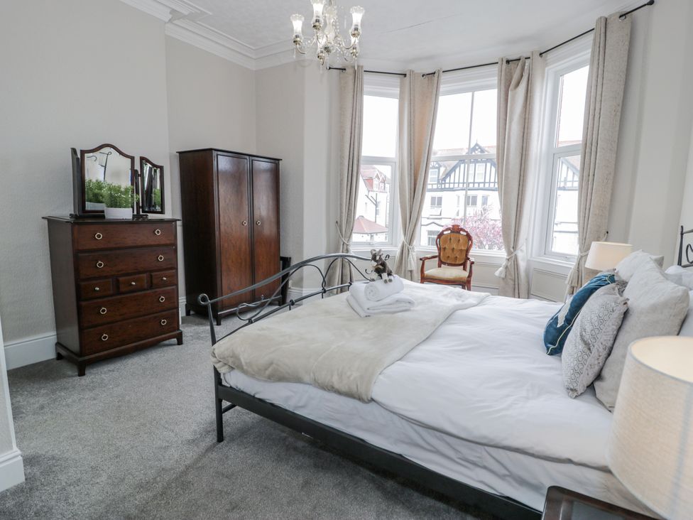 A bedroom with a bed and wardrobe at The Keep in Llandudno
