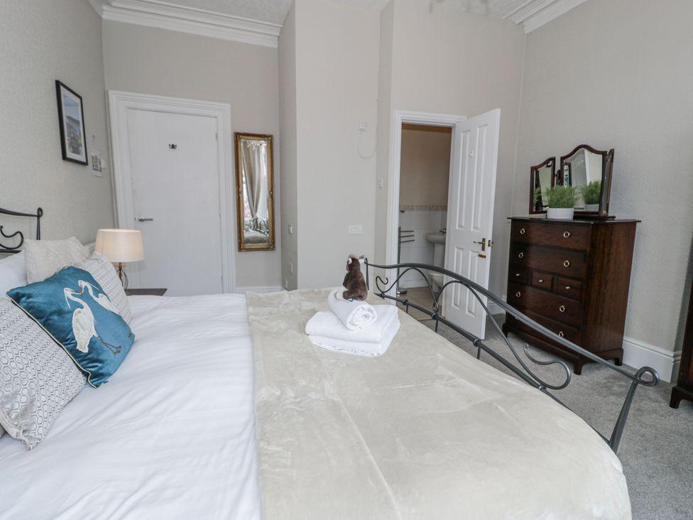 A bedroom with a bed and dresser at The Keep in Llandudno