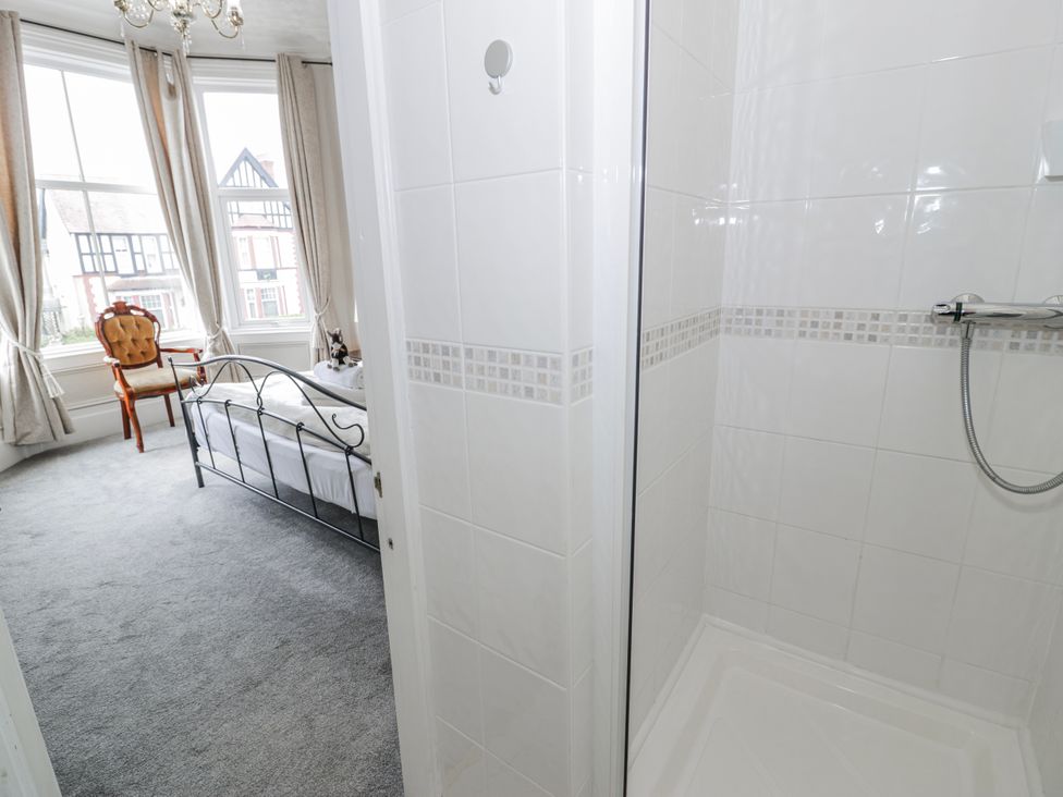 A bedroom with a bed and a shower at The Keep in Llandudno