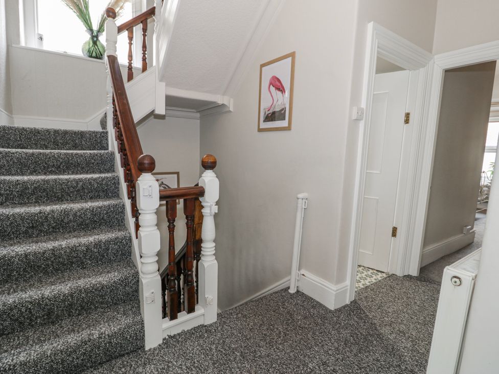 A staircase and hallway with a framed picture at The Keep in Llandudno