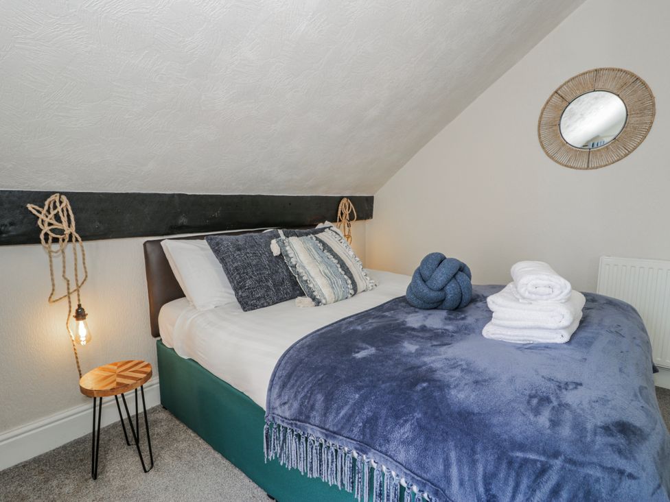 A bedroom with a bed and decorative items at The Keep in Llandudno