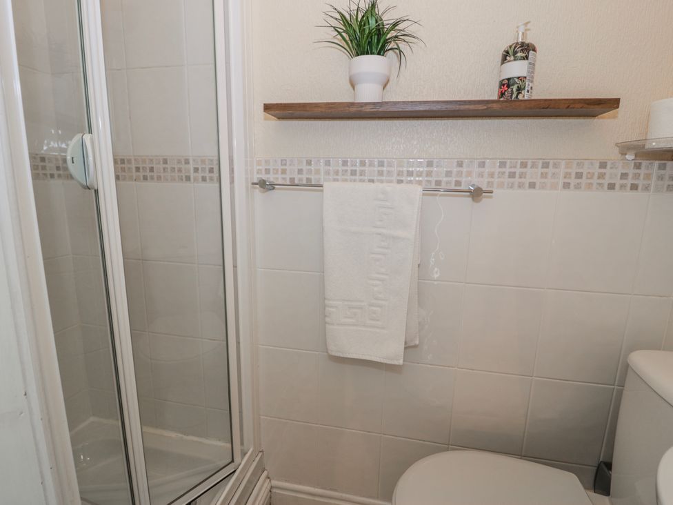 A bathroom with a shower and towel rack at The Keep in Llandudno
