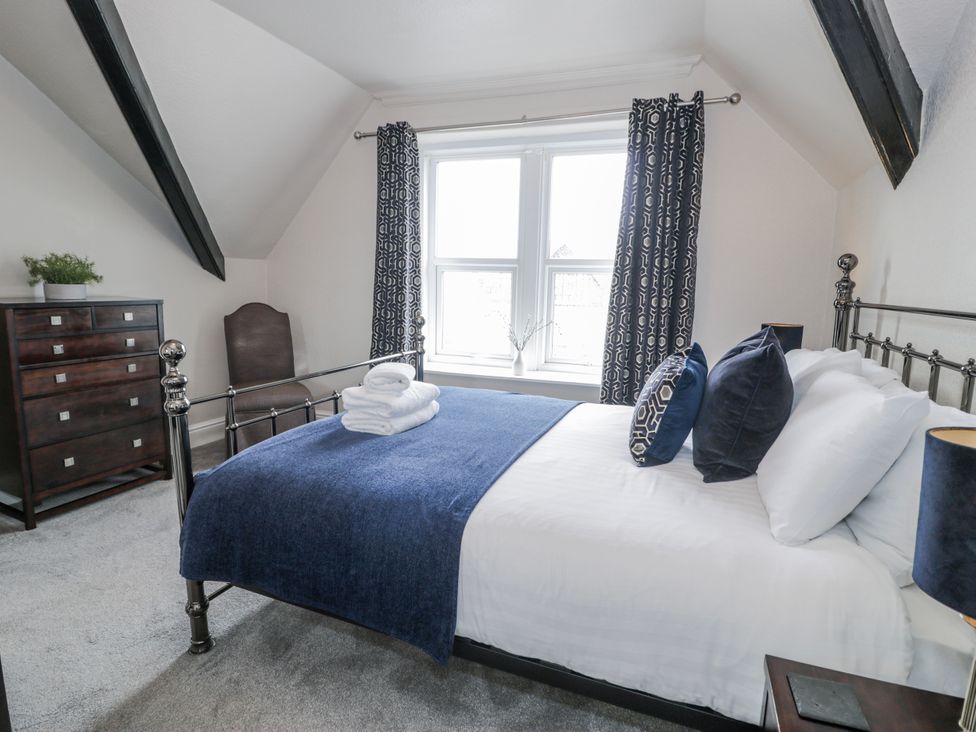 A bedroom with a bed and dresser at The Keep in Llandudno