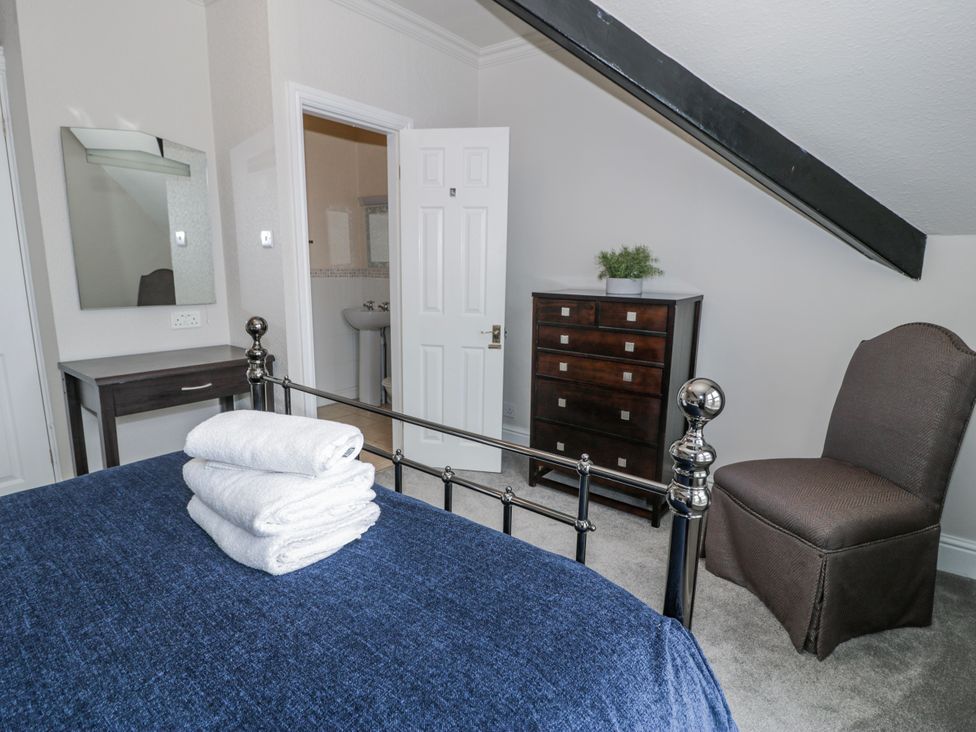 A bedroom with a bed towels on it at The Keep in Llandudno