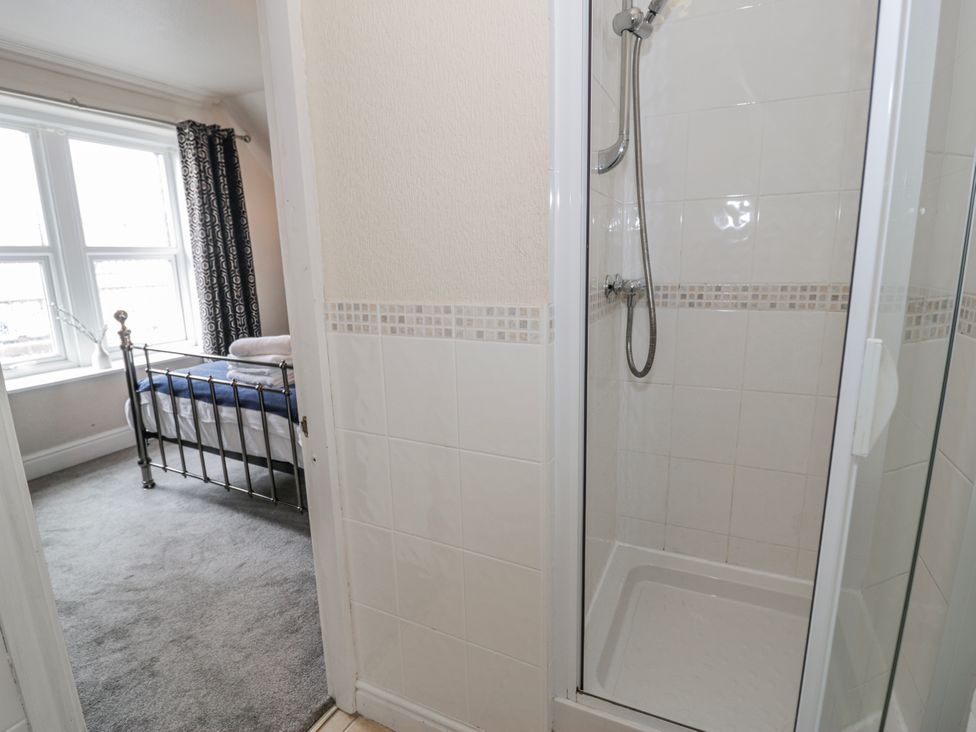 A shower area next to a bedroom with a bed at The Keep in Llandudno