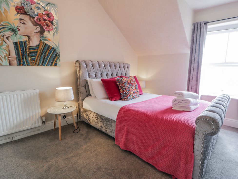 A bedroom with a bed and side table at The Keep in Llandudno