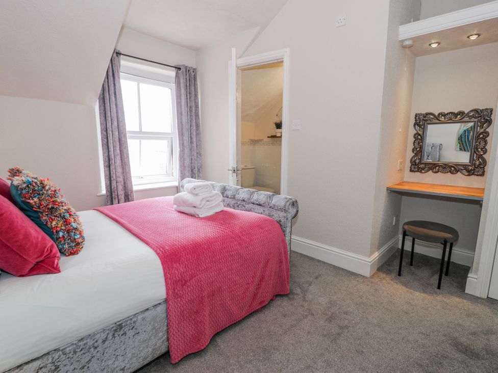 A bedroom with a bed and desk at The Keep in Llandudno