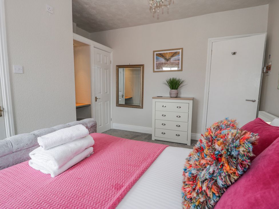 A bedroom with a bed and dresser at The Keep in Llandudno