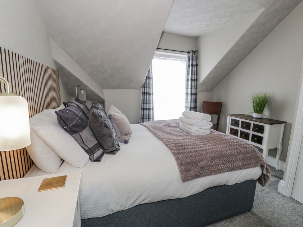 A bedroom with a bed and window at The Keep in Llandudno