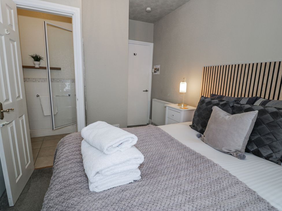 A bedroom with a bed and towels at The Keep in Llandudno