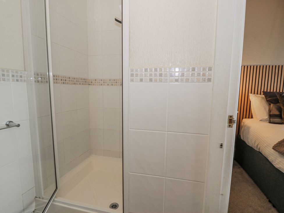 A shower and a door leading to a bedroom at The Keep in Llandudno