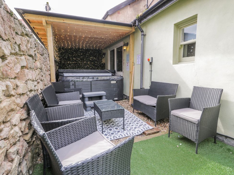 An outdoor seating area with a hot tub and seating at The Keep in Llandudno