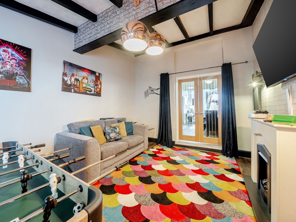 A living room with a sofa and a foosball table at The Keep in Llandudno