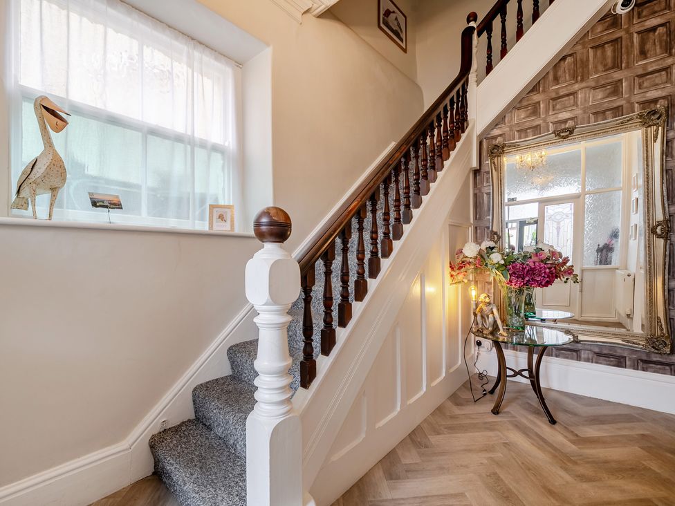 A hallway with a staircase and decorative items at The Keep in Llandudno