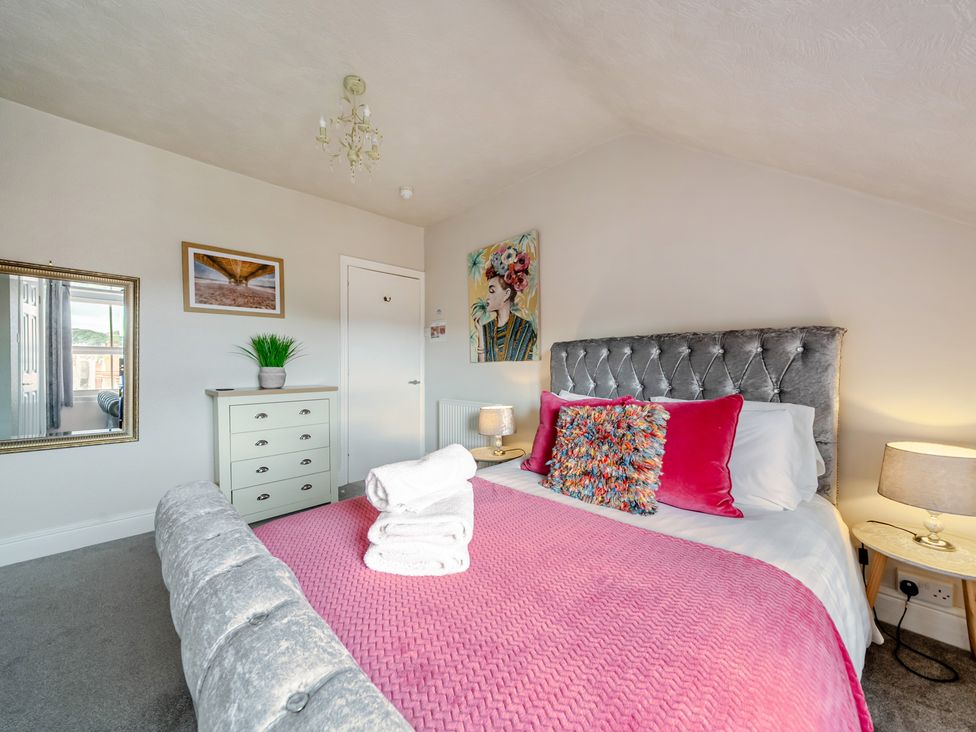 A bedroom with a bed and side table at The Keep in Llandudno
