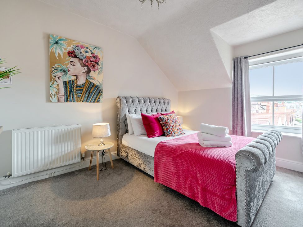 A bedroom with a bed and a painting on the wall at The Keep in Llandudno