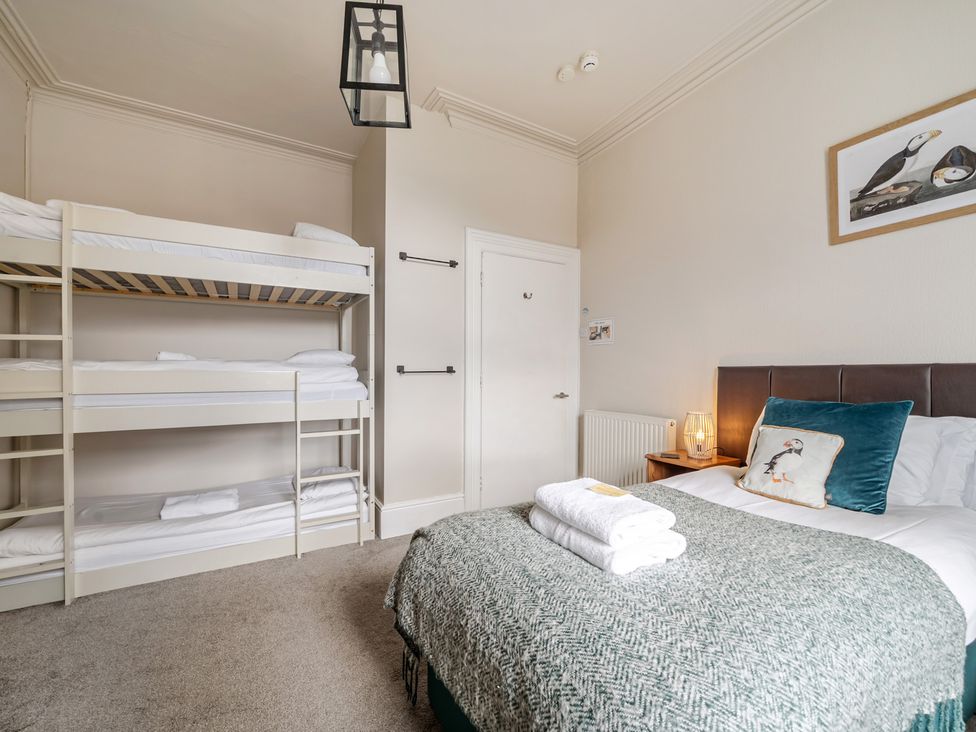 A bedroom with a double bed and a bunk bed at The Keep in Llandudno