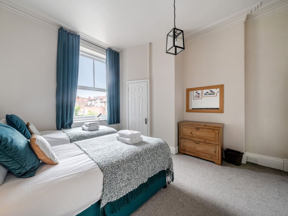 A bedroom with two beds and a dresser at The Keep in Llandudno