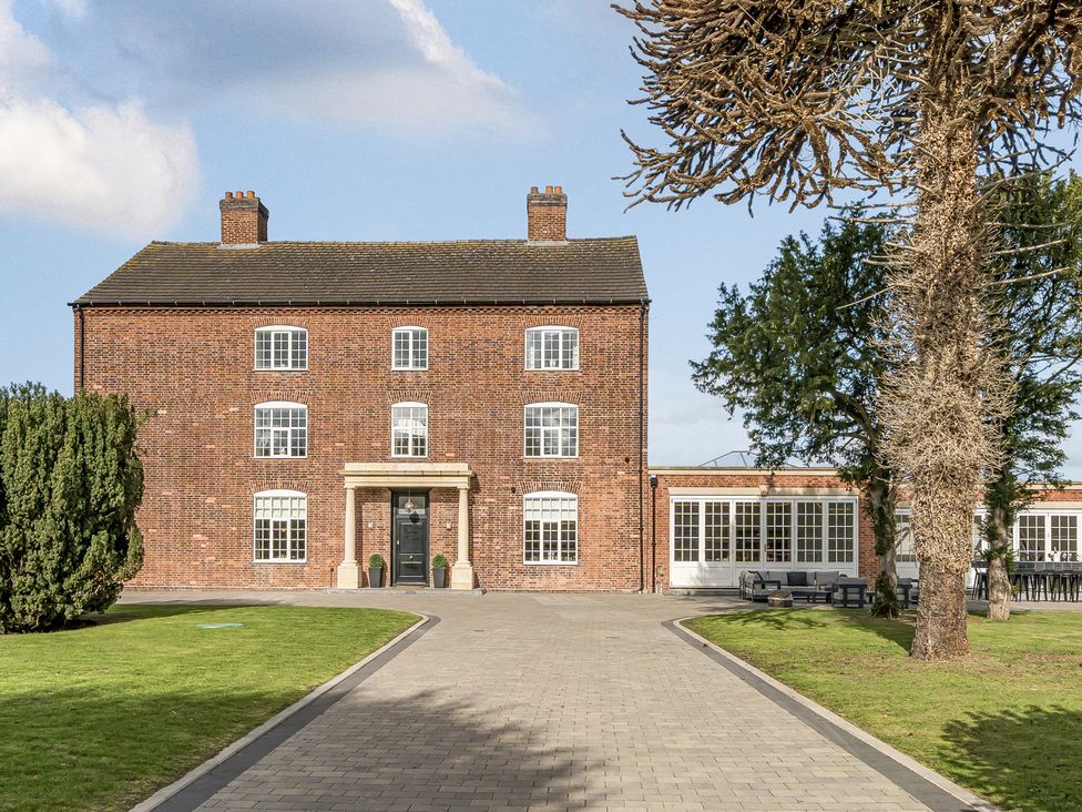A brick house with a garden and pathway at Otherton Hall in Penkridge