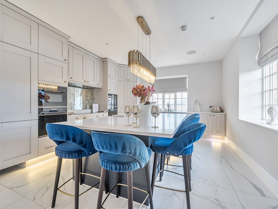 A kitchen with a large island and bar stools at Otherton Hall in Penkridge