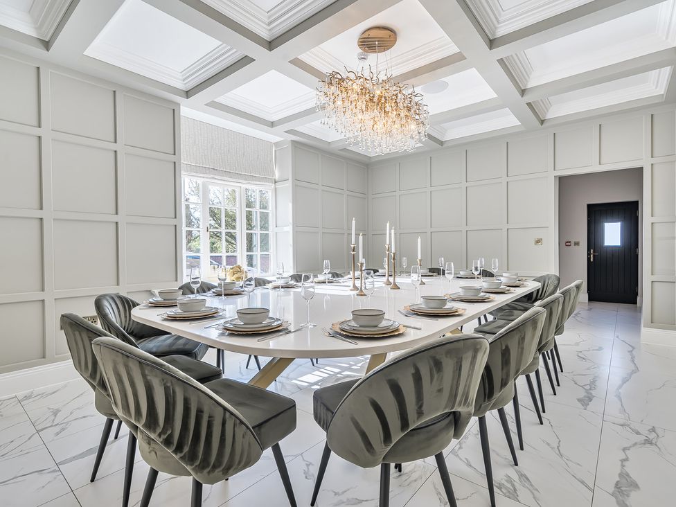 A dining room with a large table and chairs at Otherton Hall in Penkridge