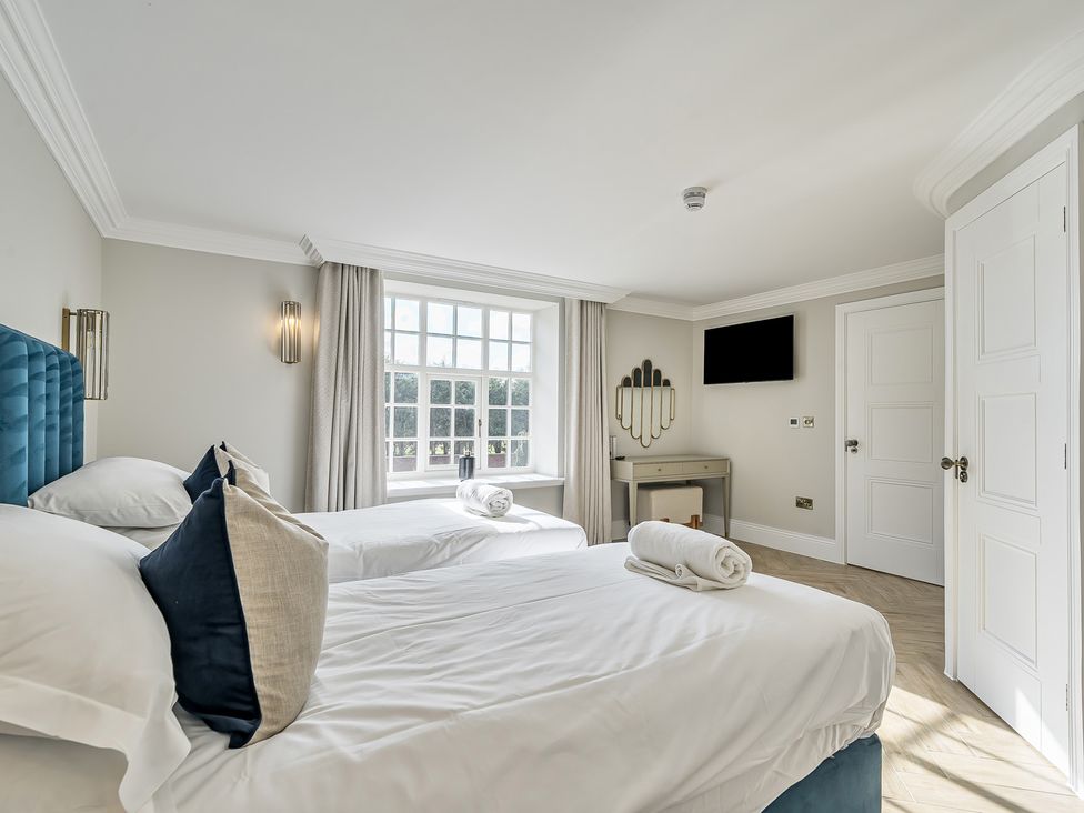 A bedroom with two beds and a window at Otherton Hall in Penkridge