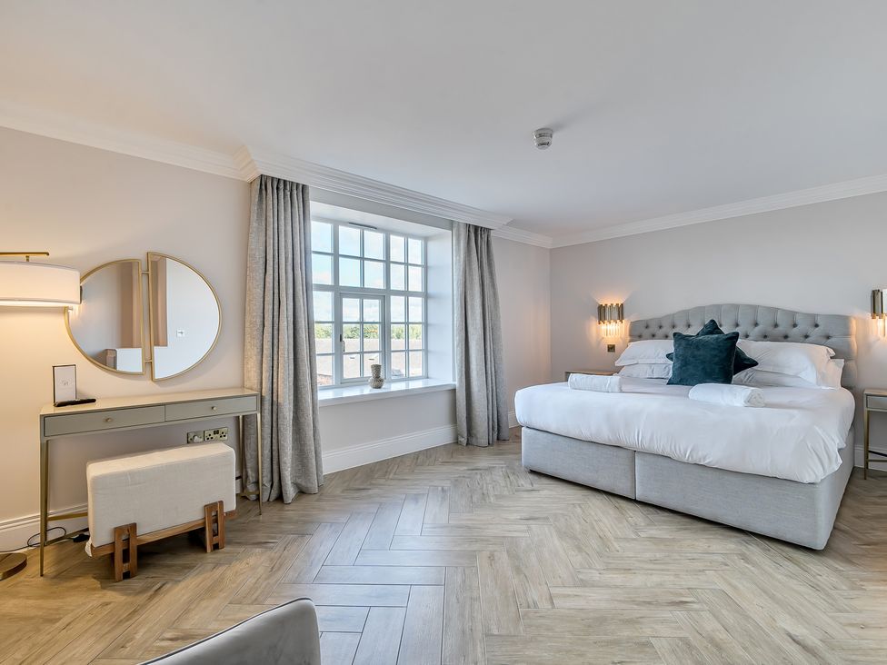 A bedroom with a bed and mirror at Otherton Hall in Penkridge