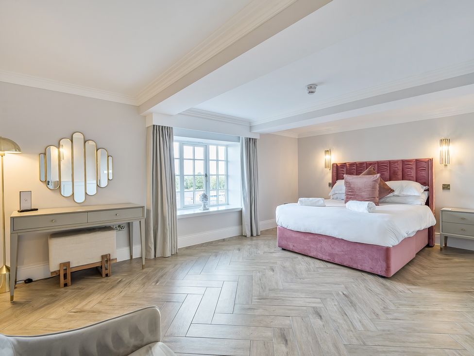 A bedroom with a bed and mirror at Otherton Hall in Penkridge
