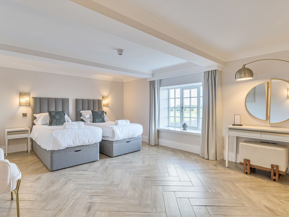A bedroom with two beds and a desk at Otherton Hall Penkridge