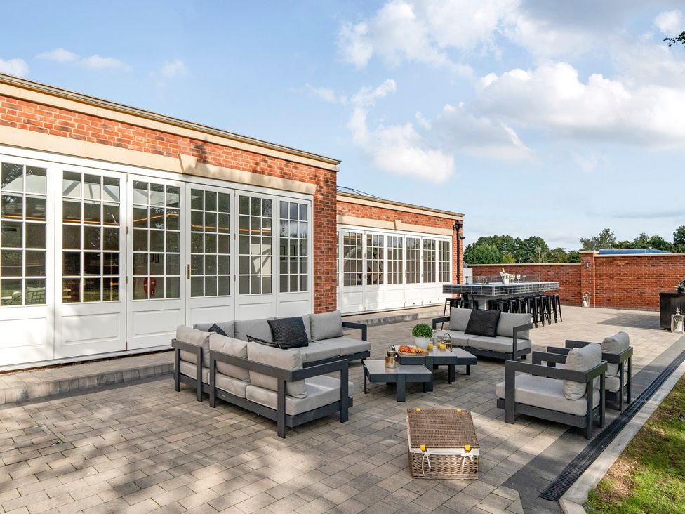 An outdoor patio with seating and a table at Otherton Hall Penkridge