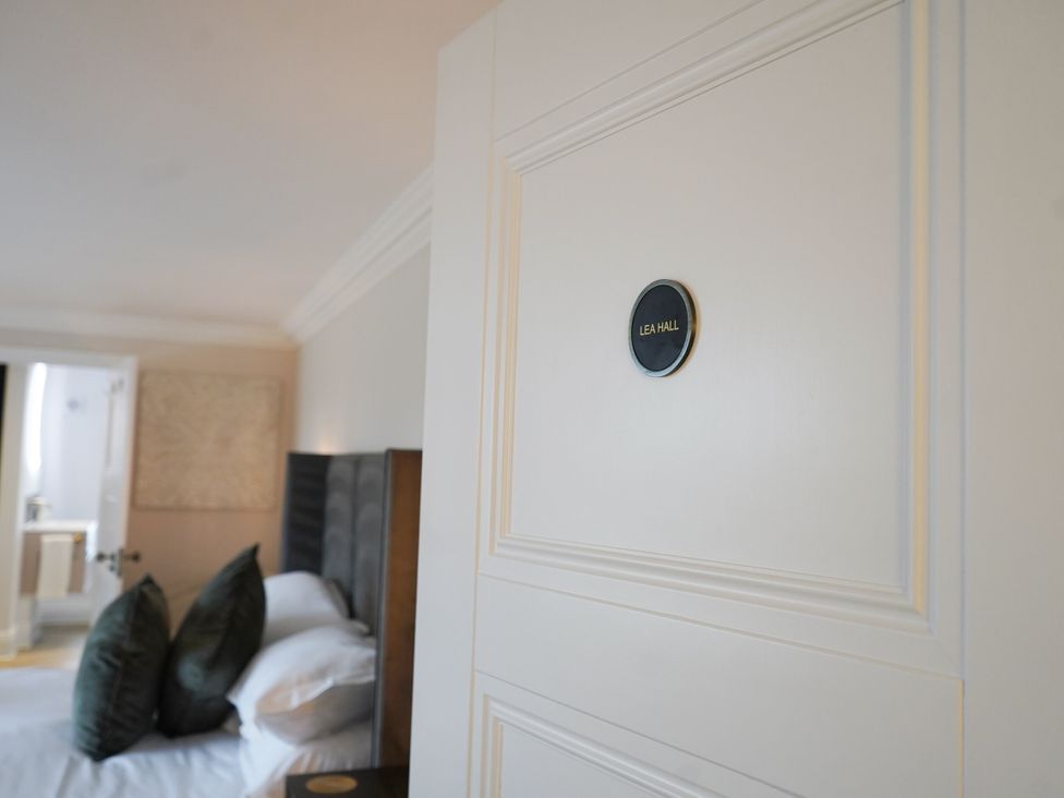 A bedroom with a door labeled Lea Hall at Otherton Hall Penkridge