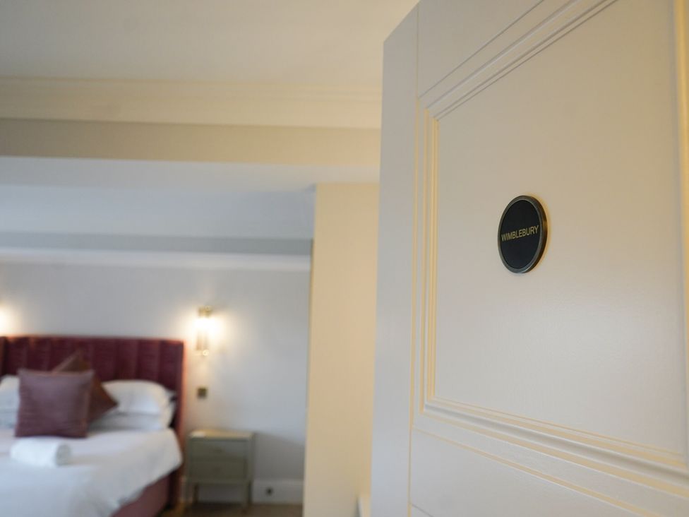 A door labeled Wimblebury with a view of a bed in the bedroom at Otherton Hall in Penkridge