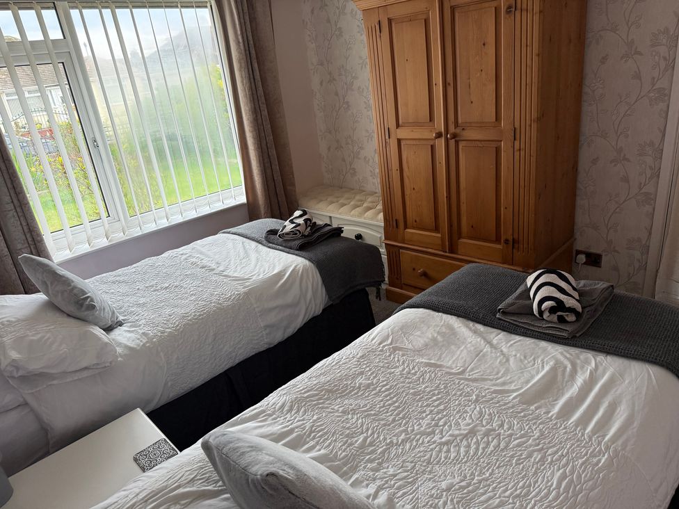 A bedroom with two beds and a wardrobe at Bungalow by the Sea Cleveleys