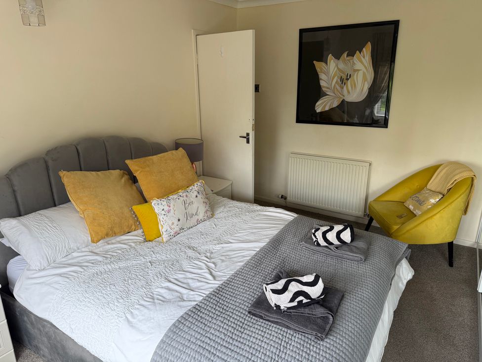 A bedroom with a bed and an armchair at Bungalow by the Sea in Cleveleys
