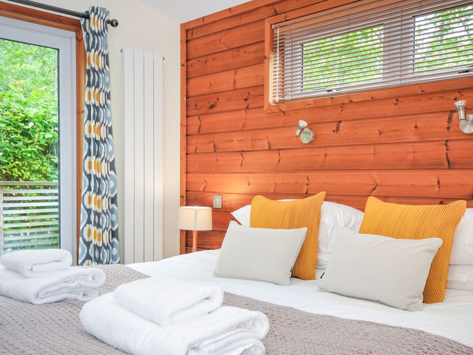 A bedroom with a bed and curtains at 5 Faraway Fields in Dobwalls