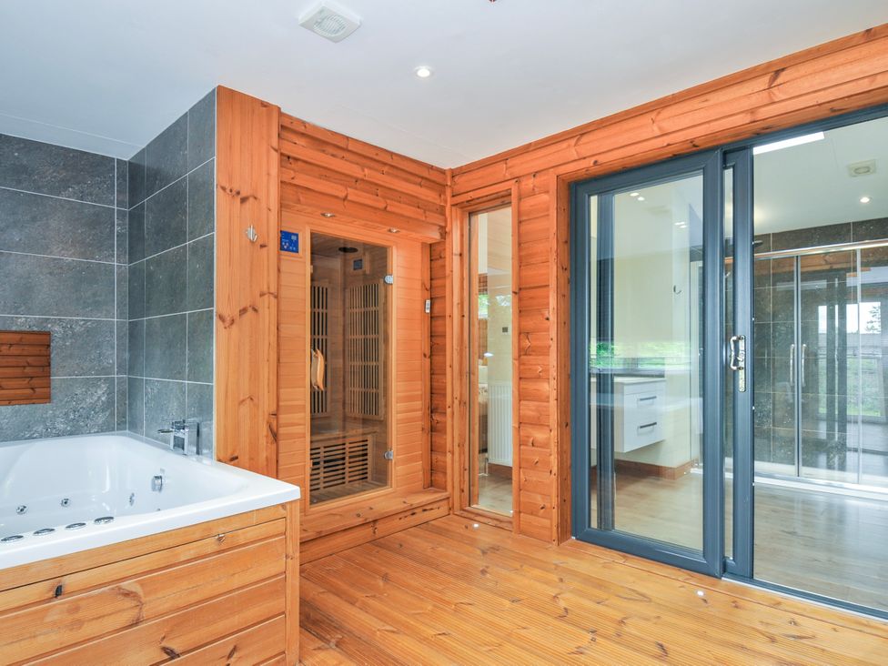 A bathroom with a bathtub and a sauna at 5 Faraway Fields in Dobwalls