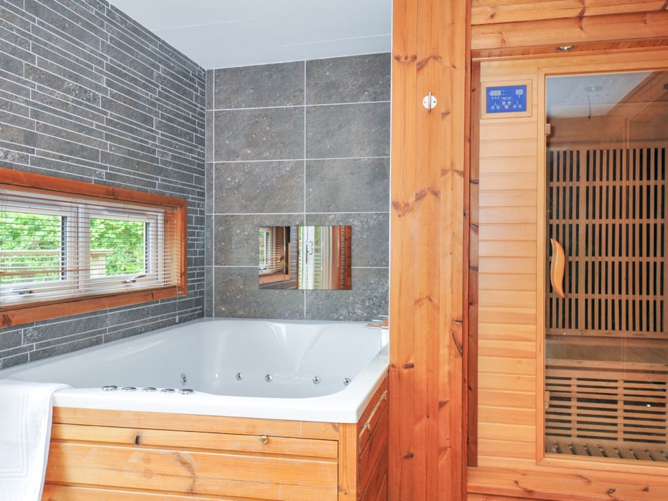 A bathroom with a bath tub and a sauna at 5 Faraway Fields in Dobwalls