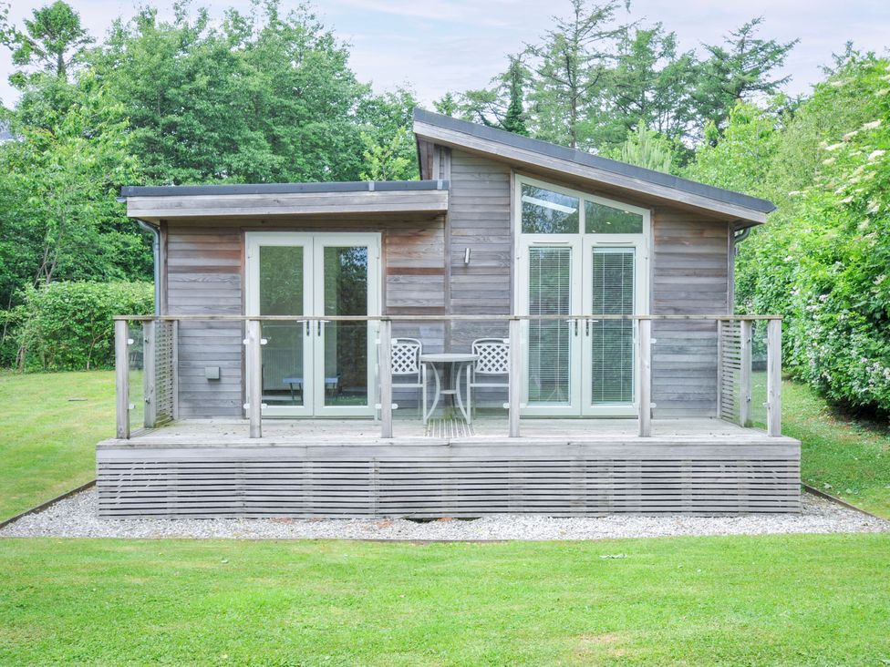 A cottage with a deck and chairs at 5 Faraway Fields Dobwalls