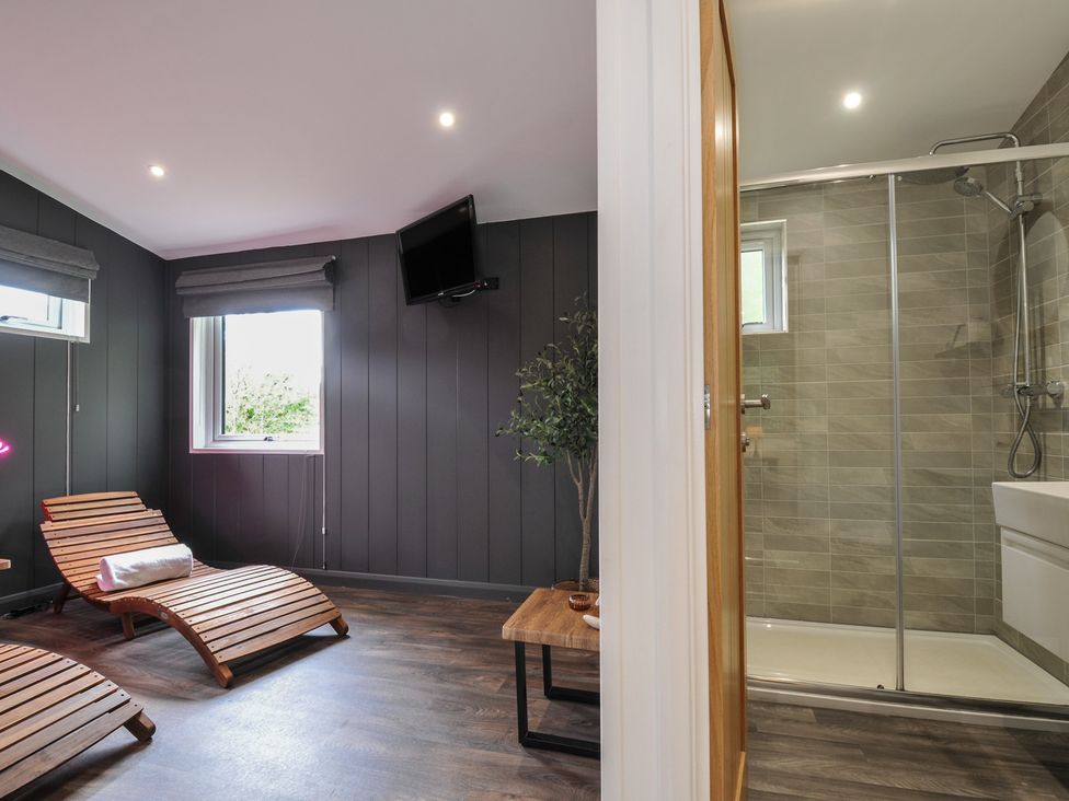 A spa room with lounge chairs and a shower at 24 Meadow Retreat in Dobwalls