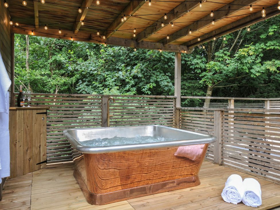 An outdoor hot tub on a wooden deck at 24 Meadow Retreat in Dobwalls