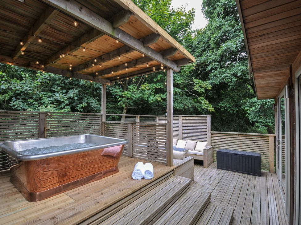An outdoor space with a hot tub and seating at 24 Meadow Retreat in Dobwalls