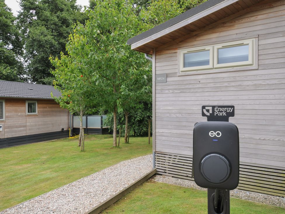An outdoor area with a charging point and wooden buildings at 24 Meadow Retreat in Dobwalls