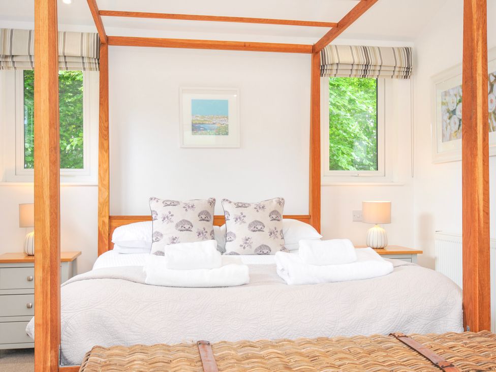 A bedroom with a four-poster bed and bedside table at 1 Horizon View in Dobwalls