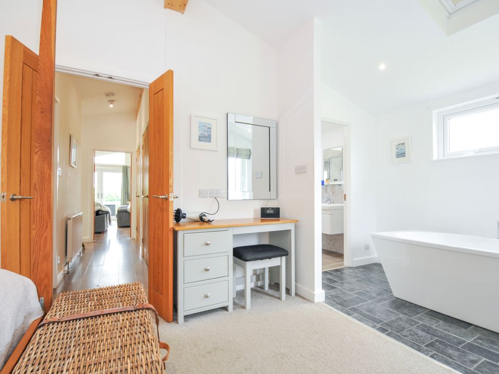 A bathroom with a bathtub and a desk at 1 Horizon View in Dobwalls