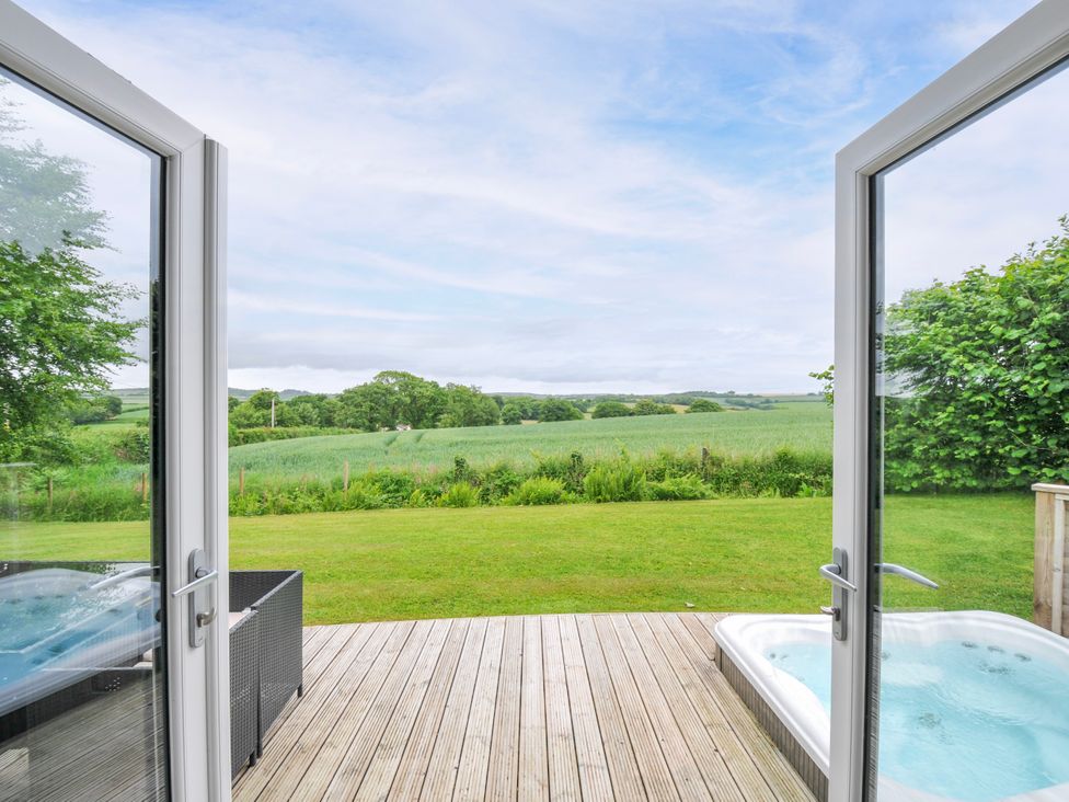 An outdoor area with a wooden deck and hot tub at 1 Horizon View in Dobwalls