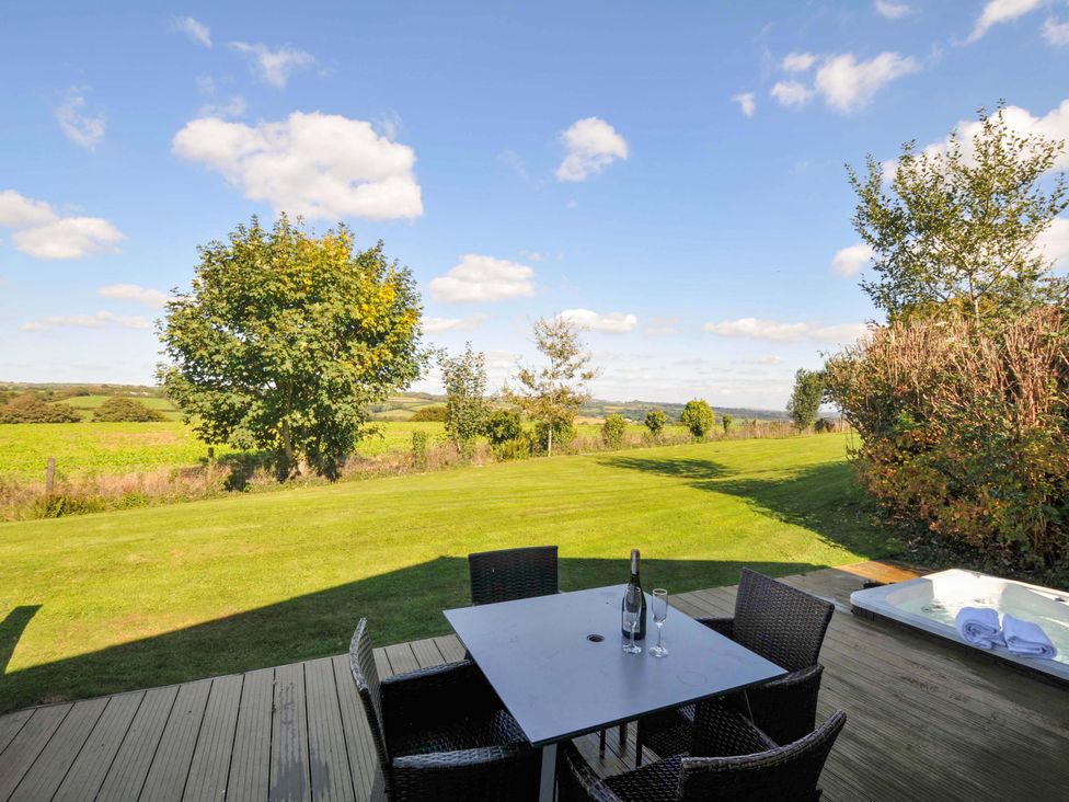 A patio with a table and chairs overlooking a garden at 3 Horizon View in Dobwalls