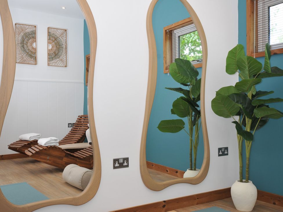 A spa room with wooden chairs and large mirrors at 12 Meadow Retreat in Dobwalls