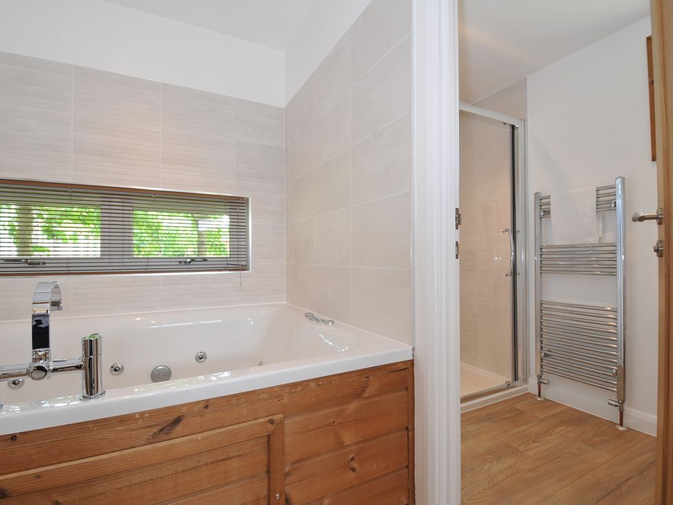 A bathroom with a bathtub and a shower at 12 Meadow Retreat in Dobwalls