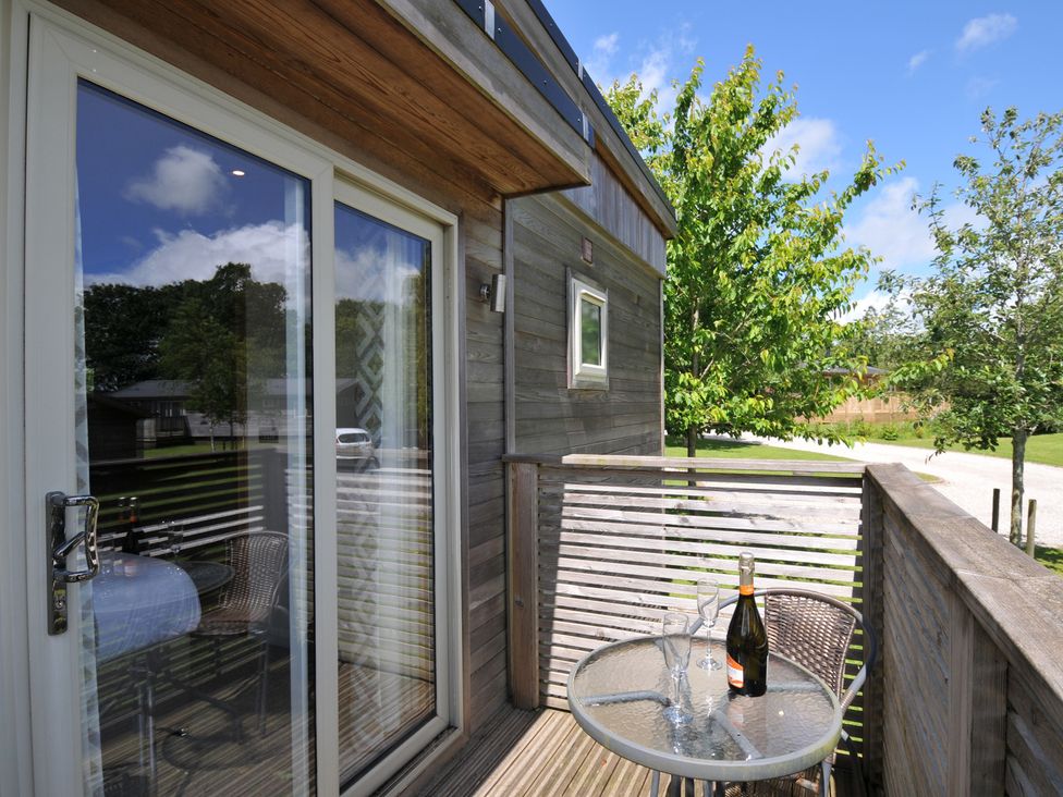 An outdoor area with a glass table and champagne at 12 Meadow Retreat in Dobwalls