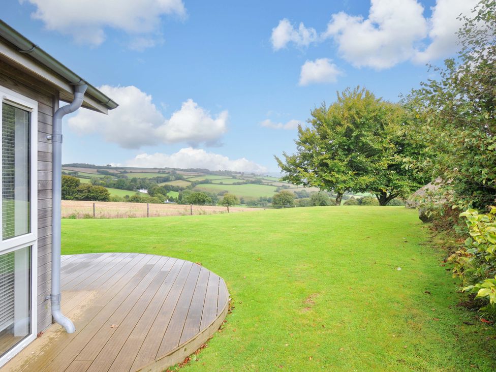 A garden with grass and a deck at 8 Horizon View in Dobwalls